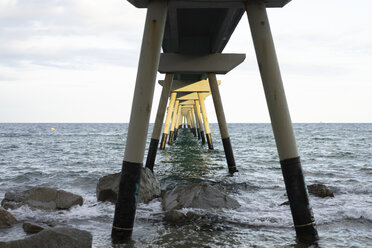 Sunlight shining on pier leading into the sea - AFVF01750