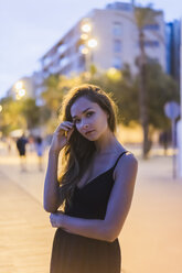 Portrait of beautiful young woman in the city at dusk - AFVF01772