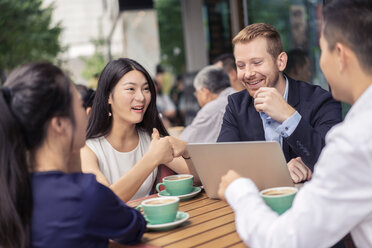 Group of businesspeople, having meeting at cafe, using laptop, outdoors - ISF19719