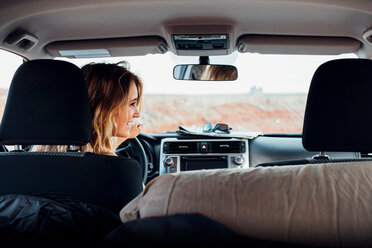 Junge Frau am Steuer eines Fahrzeugs in abgelegener Umgebung, Rückansicht, Fahrzeuginnenraum, Mexican Hat, Utah, USA - ISF19732