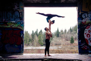 Couple practising acroyoga on outdoor stage - ISF19749