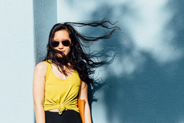 Portrait of young woman outdoors, hair blowing in breeze - ISF19799