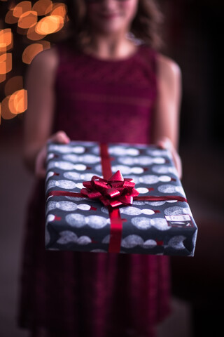 Mädchen bei der Übergabe eines Weihnachtsgeschenks, lizenzfreies Stockfoto