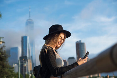 Portrait of woman looking at mobile phone smiling, New York, USA - ISF19852