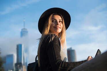 Portrait of woman wearing hat looking away smiling, New York, USA - ISF19853