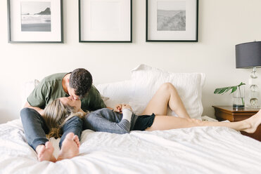 Paar entspannt sich auf dem Bett und küsst sich - ISF19866