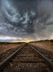 Superzelle rotiert bei Sonnenuntergang über einer unendlichen Strecke von Eisenbahnschienen, Arriba, Colorado, USA - ISF19900