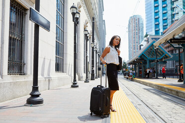 Businesswoman waiting on light rail platform - ISF19935