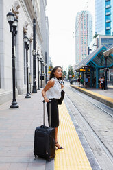 Businesswoman waiting on light rail platform - ISF19936