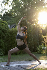 Frau übt Yoga im Garten - HHLMF00519
