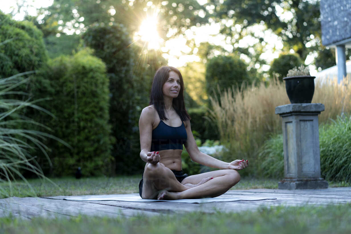 Woman practicing yoga in garden stock photo