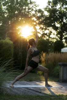 Woman practicing yoga in garden - HHLMF00551