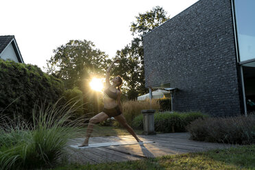 Frau übt Yoga im Garten - HHLMF00553