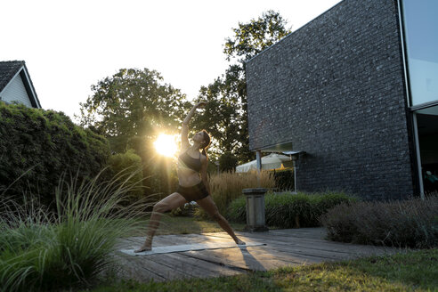 Woman practicing yoga in garden - HHLMF00553