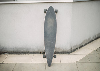 Longboard in the street leaning against a wall - RAEF02161