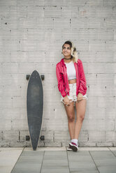 Portrait of a young woman with her long board, in front of a wall - RAEF02167