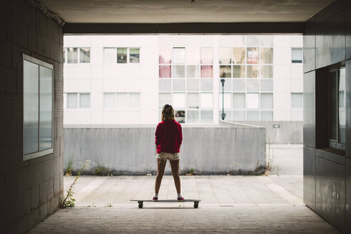 Junge Frau mit ihrem Longboard in einer Wohngegend - RAEF02174