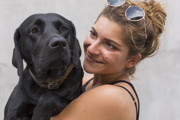 Portrait of happy young woman with her black dog - JUNF01520