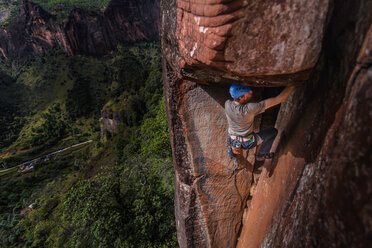 Rock climber climbing sandstone rock, elevated view, Liming, Yunnan Province, China - CUF46058