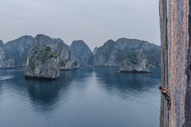 Mann beim Klettern auf einem Kalksteinfelsen, Ha Long Bay, Vietnam - CUF46099