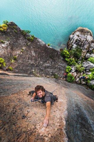 Mann klettert auf Kalksteinfelsen, Blick von oben, Ha Long Bay, Vietnam, lizenzfreies Stockfoto