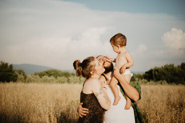Paar mit kleinem Mädchen auf einer goldenen Grasfläche, Arezzo, Toskana, Italien - CUF46210