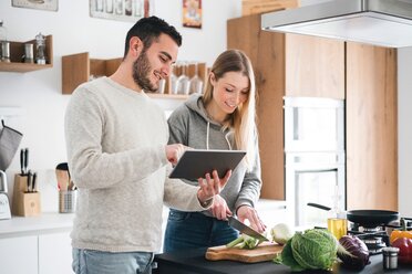 Couple preparing food using digital tablet - CUF46246