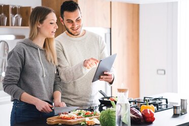 Couple preparing food using digital tablet - CUF46249