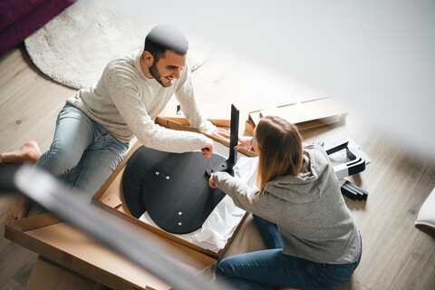 Pärchen beim Zusammenbau von Flatpack-Möbeln, lizenzfreies Stockfoto