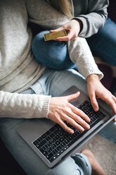 Couple with credit card using laptop, cropped view - CUF46258