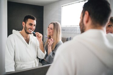 Spiegelbild eines Paares beim Zähneputzen im Badezimmer - CUF46268