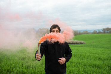 Man with flare in middle of field - CUF46274