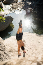 Man doing handstand on rock, Arezzo, Toscana, Italy - CUF46287