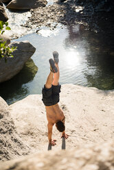 Mann macht Handstand auf einem Felsen, Arezzo, Toskana, Italien - CUF46287