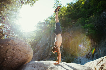 Mann macht Handstand auf einem Felsen, Arezzo, Toskana, Italien - CUF46289