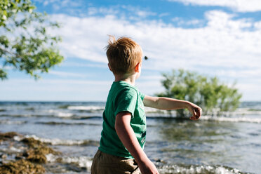 Junge wirft Stein ins Wasser, Kingston, Kanada - CUF46308