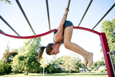 Girl on horizontal ladder climber in playground, Kingston, Canada - CUF46313