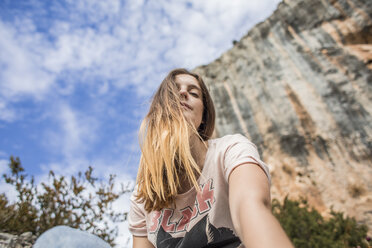 Spanien, Alquezar, Porträt einer jungen Frau bei einer Wanderung vor einer Felswand - AFVF01780