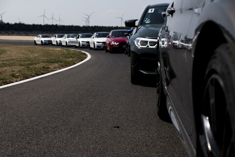 Autos in einer Reihe auf der Rennstrecke, lizenzfreies Stockfoto