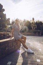 Attractive young woman wearing leopard print dress in public garden - RSGF00019