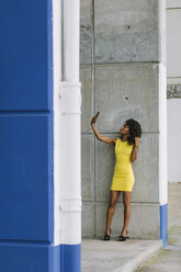 Modische Geschäftsfrau im gelben Kleid nimmt Selfie mit Smartphone - FMGF00068