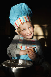 Portrait cute girl in chefs hat baking - FSIF03278