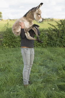 Man holding goat on farm - FSIF03375