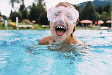 Nahaufnahme eines glücklichen Mädchens mit offenem Mund beim Schwimmen im Pool - CAVF49137