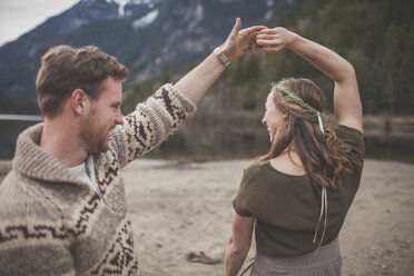Glückliches junges Paar tanzt am Seeufer im Silver Lake Provincial Park - CAVF49154