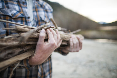 Midsection of man carrying firewood at Silver Lake Provincial Park - CAVF49159