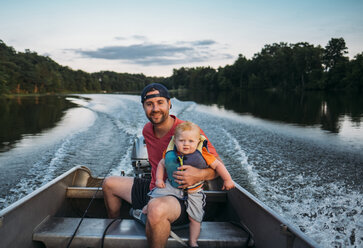 Porträt eines Vaters mit Sohn im Motorboot auf dem See - CAVF49181