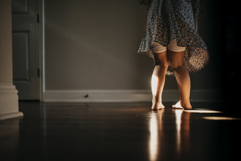 Niedriger Ausschnitt eines Mädchens, das zu Hause auf dem Boden steht - CAVF49206