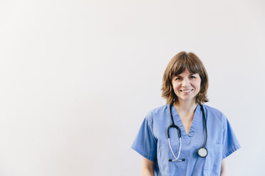 Porträt einer lächelnden Ärztin mit Stethoskop vor weißem Hintergrund - CAVF49240