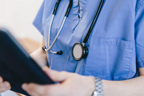 Mittelteil einer Ärztin bei der Benutzung eines Tablet-Computers im Krankenhaus - CAVF49241